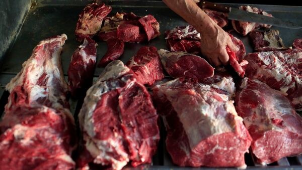 A man inspects pieces of beef at a butchery after the Chilean government suspended all meat and poultry imports from Brazil, in Santiago, Chile - Sputnik Mundo