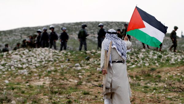 Hombre sujeta bandera palestina frente a militares israelís (archivo) - Sputnik Mundo