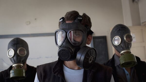 (FILES) - A file picture taken on September 15, 2013 shows volunteers wearing gas masks during a class on how to respond to a chemical attack, in the northern Syrian city of Aleppo on September 15, 2013. A source from the Organisation for the Prohibition of Chemical Weapons (OPCW) declared on November 5, 2015 - Sputnik Mundo
