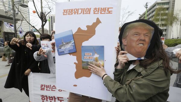 Protesters hold a cutout of U.S. President Donald Trump and images of the USS Carl Vinson aircraft carrier and U.S. missile defense system THAAD, right, on a map of Korean Peninsula during a rally against U.S. deployment of the aircraft carrier to the Korean Peninsula, near the U.S. embassy in Seoul, South Korea, Thursday, April 13, 2017 - Sputnik Mundo
