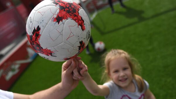 Una niña sostiene un balón en el primer parque temático de la Copa Confederaciones 2017 en Moscú - Sputnik Mundo