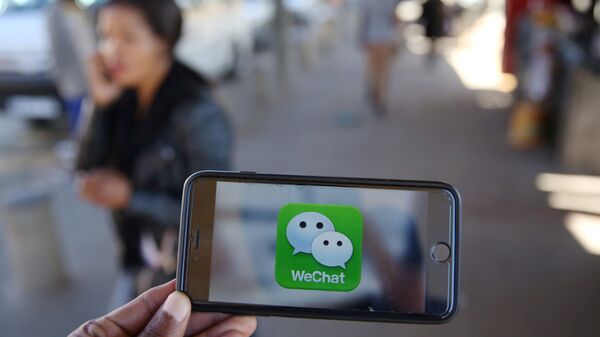 Un logotipo de WeChat se muestra en un teléfono móvil - Sputnik Mundo