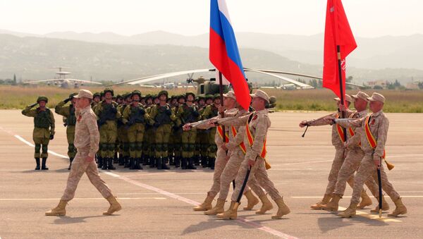 Los militares rusos durante el desfile militar del Día de la Victoria en la base aérea siria Hmeymim - Sputnik Mundo