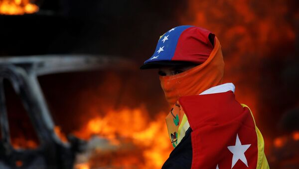 Un participante de las protestas contra el presidente Nicolás Maduro en Caracas, Venezuela - Sputnik Mundo
