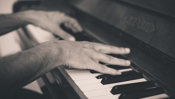Un hombre tocando piano (imagen referencial) - Sputnik Mundo