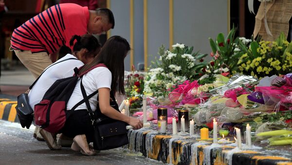Flores en memoria de las víctimas causadas por el asaltante del casino de Manila, Filipinas - Sputnik Mundo