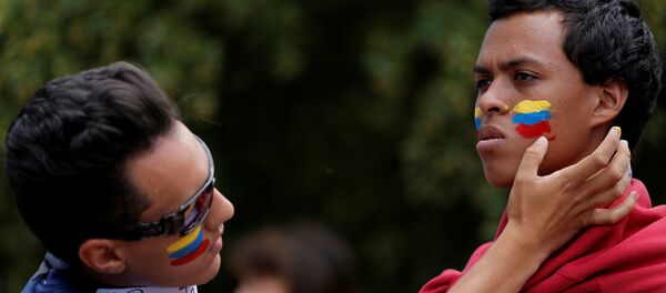 La gente pintando la bandera de Venezuela en las mejillas La gente pintando la bandera de Venezuela en las mejillas - Sputnik Mundo