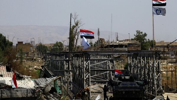 Un vehículo militar y las banderas de Irak cerca del puente destruido en Mosul (archivo) - Sputnik Mundo