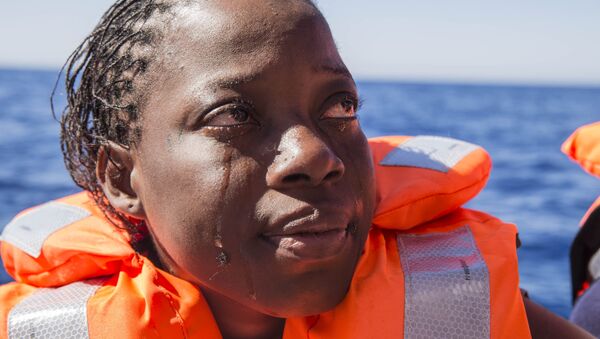 Una mujer de Costa de Marfil llora después de haber sido rescatada por los equipos de búsqueda y rescate de Médicos Sin Fronteras en el Mar Mediterráneo. - Sputnik Mundo