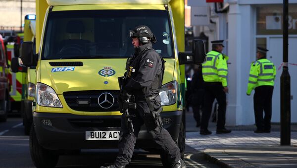 Un policía junto al equipo de emergencia en Londres, el Reino Unido - Sputnik Mundo