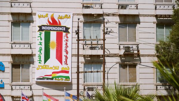 El cartel con la bandera de Kurdistán iraquí - Sputnik Mundo