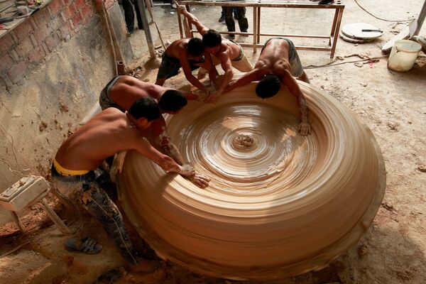 Los obreros fabrican una bañera de porcelana en una planta en Jingdezhen, China - Sputnik Mundo