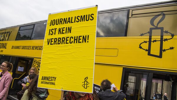 Una activista de Amnistía Internacional con un cartel: Periodismo no es crimen - Sputnik Mundo