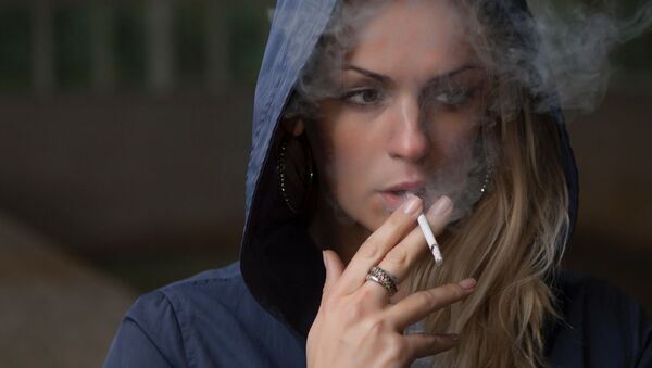 Una mujer fumando - Sputnik Mundo