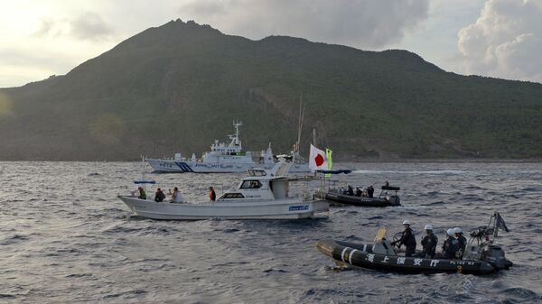 Unos barcos de la Guardia Costera japonesa navegan junto al bote pesquero de los activistas japoneses advirtiendo a los activistas que se alejen de un grupo de islas en disputa llamado Diaoyu por China y Senkaku por Japón - Sputnik Mundo