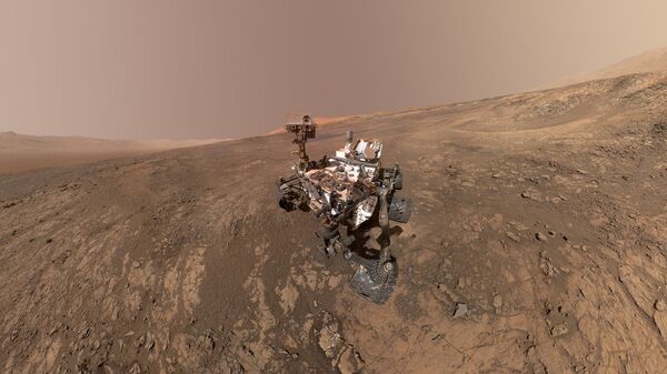 Este autorretrato del rover Curiosity de la NASA muestra el vehículo en la cresta Vera Rubin. Justo detrás del rover empieza una pendiente arcillosa que los científicos están ansiosos por comenzar a explorar. En la próxima semana, Curiosity comenzará a subir esta cuesta. - Sputnik Mundo