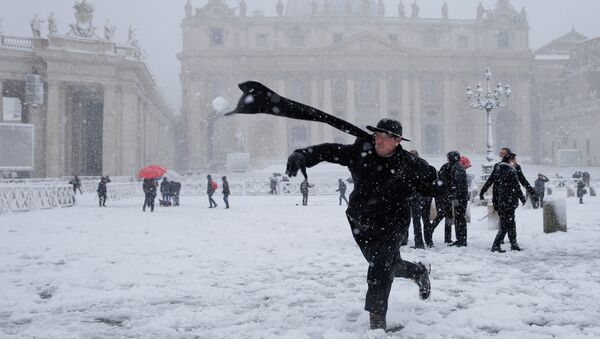 Un cura lanza una bola de nieve en la Plaza de San Pedro, en el Vaticano - Sputnik Mundo