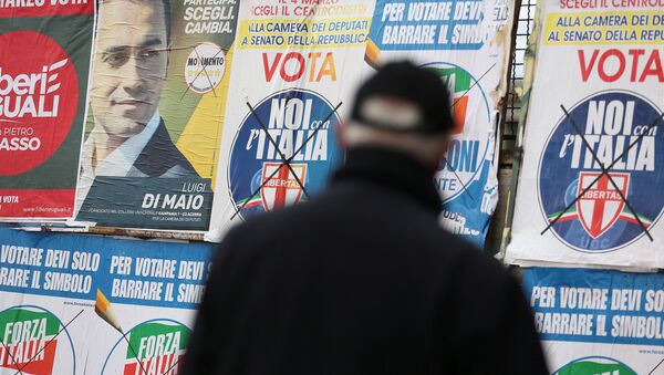 Un hombre mira afiches electorales en Pomigliano D'Arco, en las afueras de Nápoles. - Sputnik Mundo