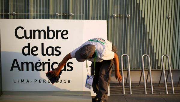 Una mujer limpia un cartel en la previa de la VIII Cumbre de las Américas en Lima, Perú. - Sputnik Mundo