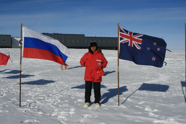 Alexandr Nóvikov, investigador de la Universidad Nacional de Investigaciones Nucleares de Rusia (MEPhI), junto a las banderas de Rusia y de Nueva Zelanda, países participantes en los estudios en la Antártida - Sputnik Mundo