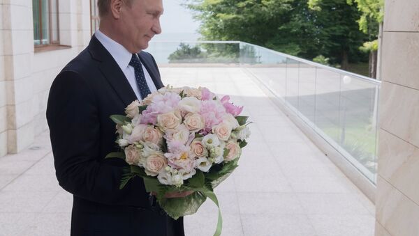 Vladímir Putin, presidente de Rusia, con un ramo de flores - Sputnik Mundo