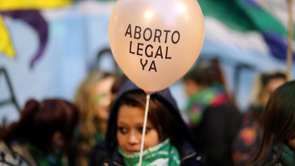 A demonstrator holds a baloon that reads Legal abortion now - Sputnik Mundo