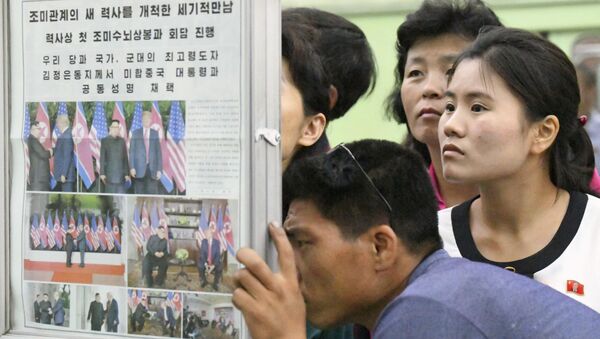 Los norcoreanos leen en un periódico sobre la cumbre entre EEUU y Corea del Norte - Sputnik Mundo