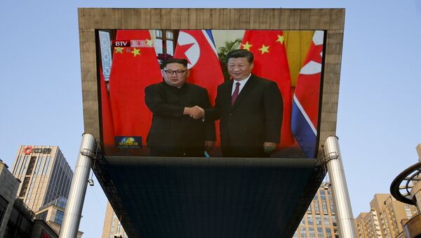 La pantalla muestra la reunión entre líder norcoreano, Kim Jong-un, y presidente chino, Xi Jinping, Pekín, China - Sputnik Mundo