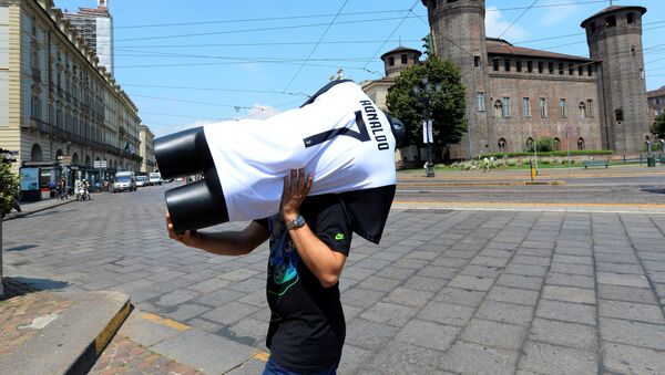 Un hombra carga un maniquí con la camiseta de Cristiano Ronaldo en Turín - Sputnik Mundo
