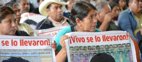 Personas sostienen carteles que recuerdan a los 43 desaparecidos de Ayotzinapa, en una visita de la Comisión Interamericana de Derechos Humanos a la escuela normal en la que estudiaban, en 2015. Personas sostienen carteles que recuerdan a los 43 desaparecidos de Ayotzinapa, en una visita de la Comisión Interamericana de Derechos Humanos a la escuela normal en la que estudiaban, en 2015. - Sputnik Mundo