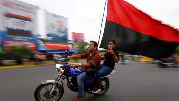 Dos motociclistas con una bandera del Frente Sandinista de Liberación Nacional de Nicaragua. - Sputnik Mundo