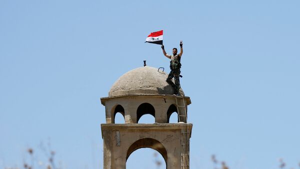 Un soldado sirio con su bandera - Sputnik Mundo
