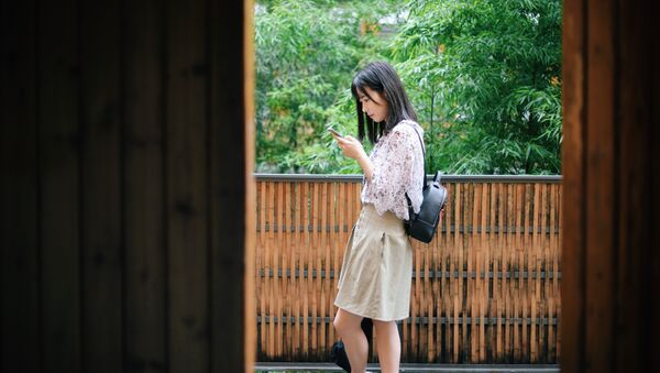 Una joven china con un smartphone - Sputnik Mundo