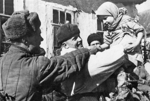 Soldados del Ejército Rojo con los habitantes de un pueblo liberado tras la batalla de Kursk (1943) - Sputnik Mundo