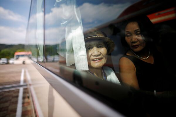 Una anciana surcoreana mira por la ventana del autobús. - Sputnik Mundo
