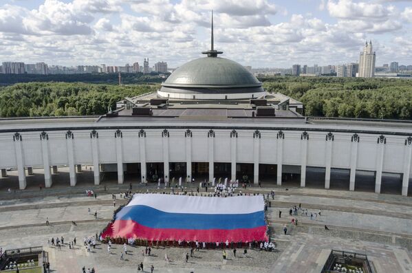 La bandera estatal de la Federación de Rusia se despliega en la plaza del Parque de la Victoria, en Moscú, para celebrar su día. - Sputnik Mundo