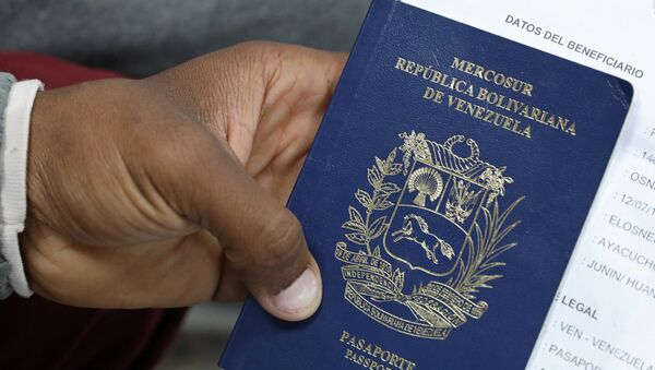 Un migrante venezolano muestra su pasaporte - Sputnik Mundo
