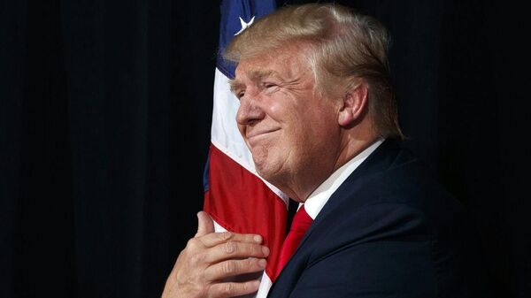 El presidente Donald Trump abraza la bandera de EEUU (archivo) - Sputnik Mundo