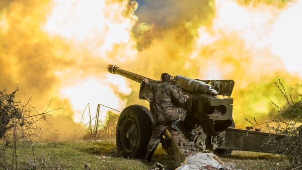 Un soldado sirio dispara de una pieza de artilleria en Idlib - Sputnik Mundo
