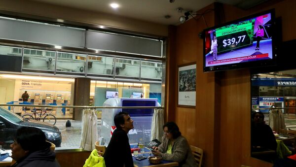 Un hombre ve por la TV las tasas de cambio del dólar en Buenos Aires, Argentina (archivo) - Sputnik Mundo