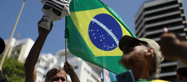 Un manifestante con la bandera de Brasil Un manifestante con la bandera de Brasil - Sputnik Mundo