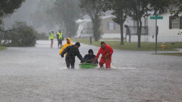 Vecinos ayudan a un anciano a evacuar una comunidad en Carolina del Norte durante el huracán Florence - Sputnik Mundo