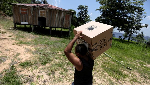Un obrero lleva la caja urna de votación a una comunidad en el río Amazonas - Sputnik Mundo