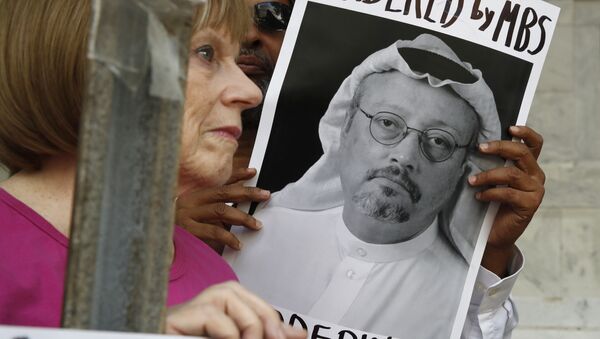 Personas con retratos del periodista saudí Jamal Khashoggi protestan en Washington - Sputnik Mundo
