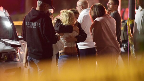 Las personas se consuelan mutuamente mientras permanecen cerca de la escena del tiroteo masivo en Thousand Oaks, California, el 8 de noviembre de 2018 - Sputnik Mundo