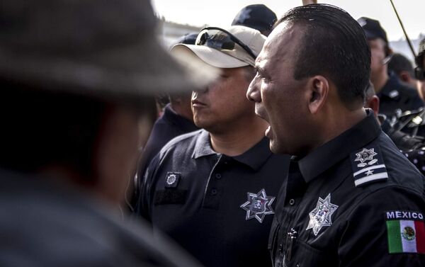 Un policía federal mexicano, Juan Carlos Morán, impide el paso de la manifestación centroamericana a la frontera con EEUU en el paso peatonal el Chaparral Un policía federal mexicano, Juan Carlos Morán, impide el paso de la manifestación centroamericana a la frontera con EEUU en el paso peatonal el Chaparral - Sputnik Mundo