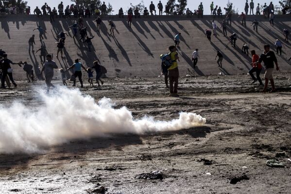 Manifestantes huyen del ataque con gases lacrimógenos de los elementos de la USBP (border patrol) al territorio mexicano - Sputnik Mundo