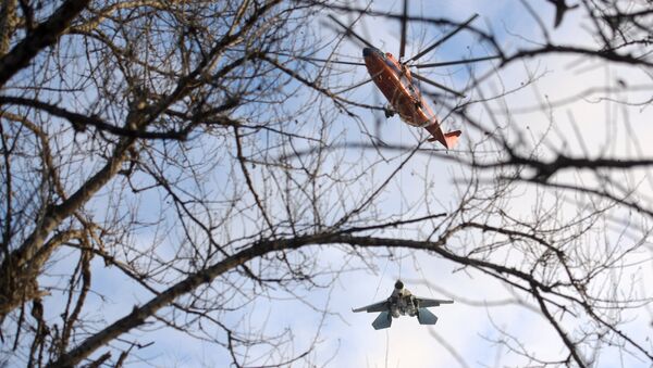 Un helicóptero Mi-26 transporta a un caza Su-27 - Sputnik Mundo