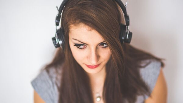 Una mujer escucha música - Sputnik Mundo