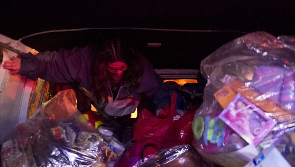 Voluntaria se prepara para repartir juguetes adentro de la camioneta del Loko - Sputnik Mundo